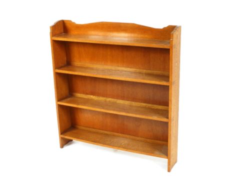 An Art Deco golden oak open fronted bookcase, having shaped top, 90cm wide x 18cm deep x 97cm high 