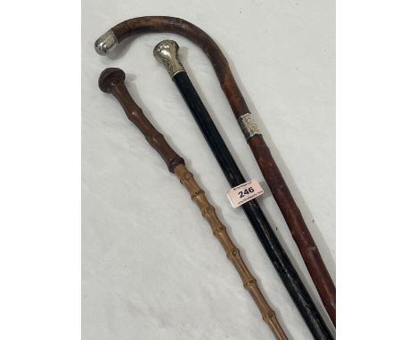 A silver mounted walking stick; another with white metal pommel and a military bamboo swagger stick (3)