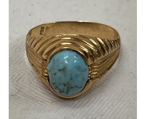 An 18ct ring set with a turquoise cabochon stone. 3.5g, size M.