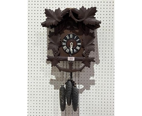 A Black Forest cuckoo quail clock with three train weight driven movement. The case 14" high.