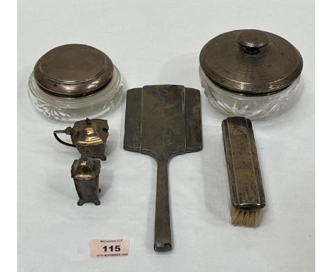 Two glass powder jars with silver covers, a silver hand mirror and clothes brush, a silver mustard pot and silver pepperette.