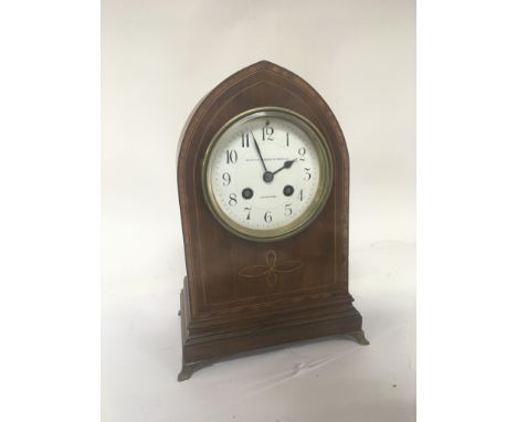 An Edwardian inlaid mahogany mantel clock with an enamel dial and brass French movement striking on a gong. With pendulum. 27