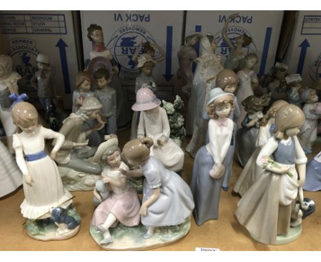 A collection of Nao figures including girl with dove on knee, large lady holding her hat and a girl with her puppy and hula h