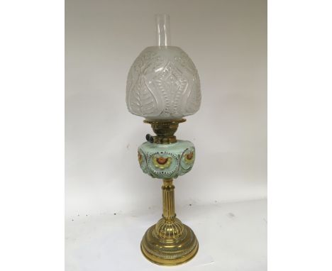 A Victorian coloured glass and brass oil lamp with a glass shade and chimney.height 65cm