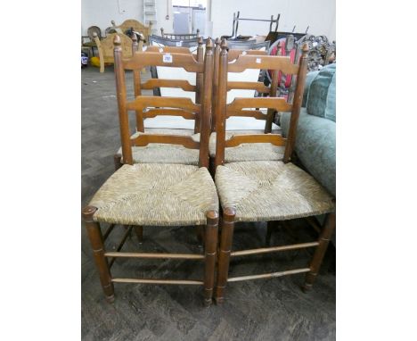 A set of four oak ladder back dining chairs with rush seats 