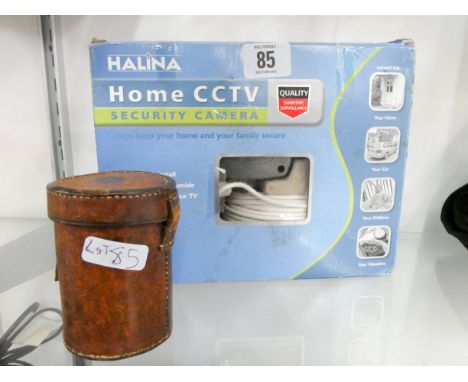 A Halina home security CCTV camera and a camera lens in a leather case