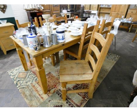 A large pine dining table on square legs together with six similar ladder back chairs with wood panel seats 