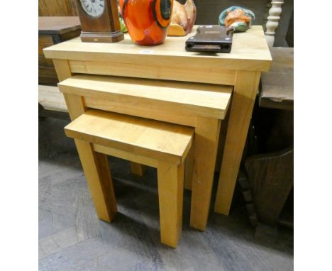 A nest of three light oak finished coffee tables 