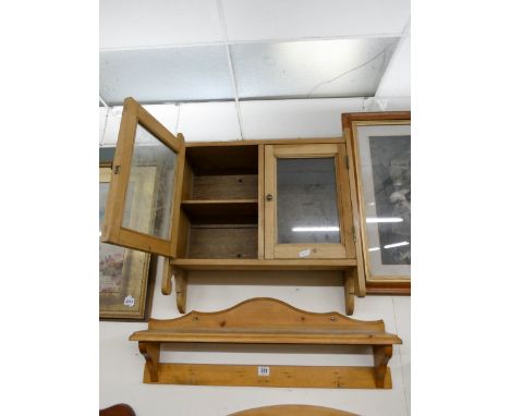 A stripped pine glazed hanging cabinet and a shelf 