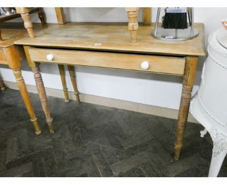 A stripped pine writing table fitted with one long drawer with ceramic handles 