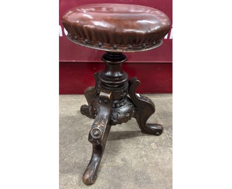 A Victorian carved walnut revolving piano stool 