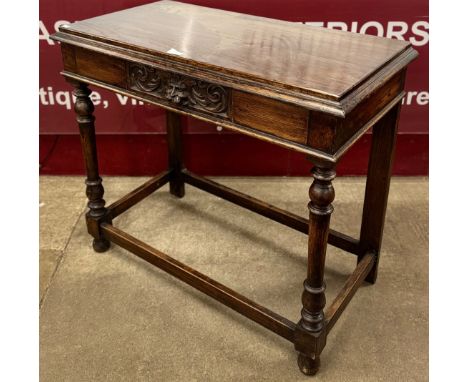An early 20th century Jacobean Revival carved oak single drawer side table 