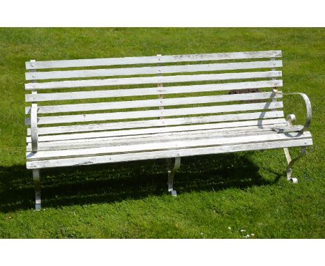 A painted wrought iron and slatted wood garden bench, early 20th century, with scrolled armrests and on outscrolled legs   83