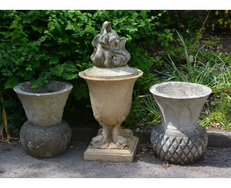 An earthenware urn and cover, 20th century, the flambeau finial above a scalloped body raised on four dolphin supports, on mo