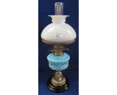 Early 20th Century brass double burner oil lamp with coloured glass moulded reservoir on brass column with ceramic base.  Opa