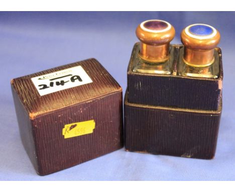 Late 19th/early 20th Century two guiilloche enamel and brass topped scents bottle in two section fitted leather case .