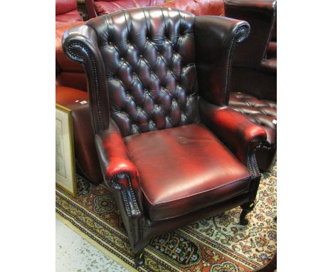 20th Century leather button back wing chair on cabriole legs.