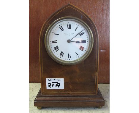 Edwardian inlaid mahogany lancet shaped boudoir clock with enamel face and French brass movement. Kental & Bent.