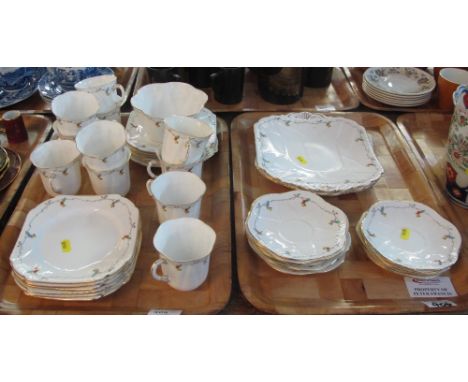 Two trays of Shelley fine bone china, registration no.: 7365121, teaware on a white ground with floral and gilt decoration co