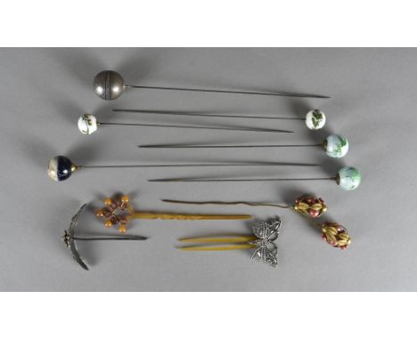 An Indian neillowork white metal spherical hatpin, decorated with birds and fauna. Together with a Chinese white metal floral