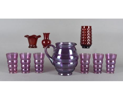A Lemonade jug with six glasses, possibly American, in lightly iridised pale Amethyst, the jug of bulbous hooped design 20 cm