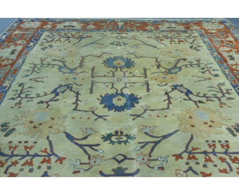 A 20th century Turkish hand knotted carpet from Konya, the cream ground with floral designs within red and blue borders, 298 