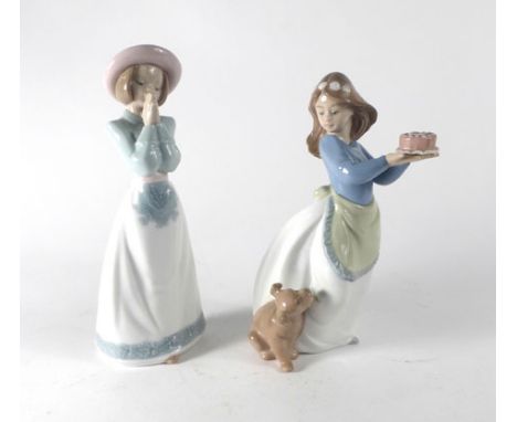 A Nao figure modelled as a young girl holding a birthday cake, her canine companion at her feet, h. 18.5 cm, together with an