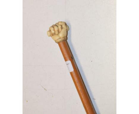 A 19th century mallacca cane, the finial carved as a clenched fist, length 81 cm 