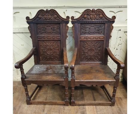 A pair of 18th century style carved oak wainscot armchairs, with solid seats and turned front legs joined by stretchers (2)Ag