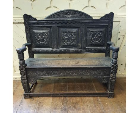 An oak bench, carved figures, flowers and lunettes, 117 cm wide 