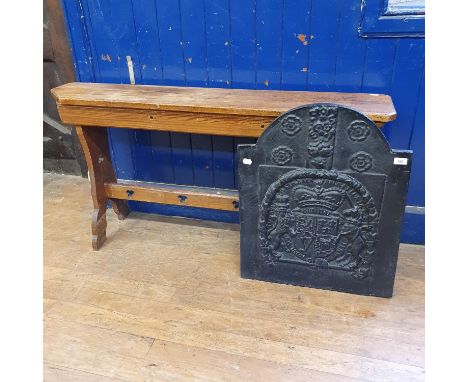 A Gothic style pine bench, 130 cm wide, and an iron fire back, with Royal coat of arms, 56 cm wide (2) 