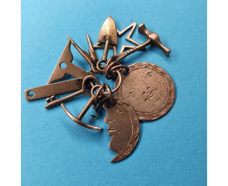 A group of early 20th century yellow coloured metal masonic charms to include moon, star, hammer, trowel, pickax, key, wing c