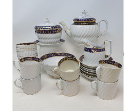 A late 18th century porcelain part tea service, with a horizontal blue band with gilt decoration, comprising teapot, slop bow