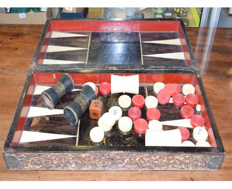 A set of late 19th century Chinese stained and natural backgammon pieces, with a folding box board, hinges broken 