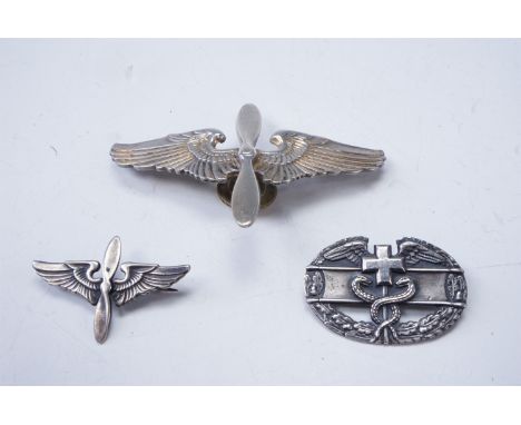A US Army Air Force aviation cadet's badge, a small "prop and wings" badge and a Combat Medic's badge, each stamped Sterling