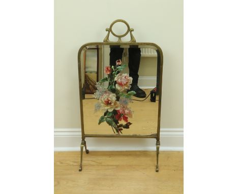 A belle epoque brass framed mirror fire screen, the bevelled mirror having a later painted floral still life, 45 x 83 cm