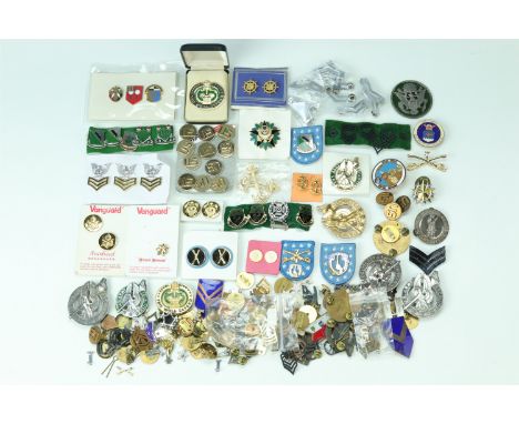 A large quantity of US army cap badges etc