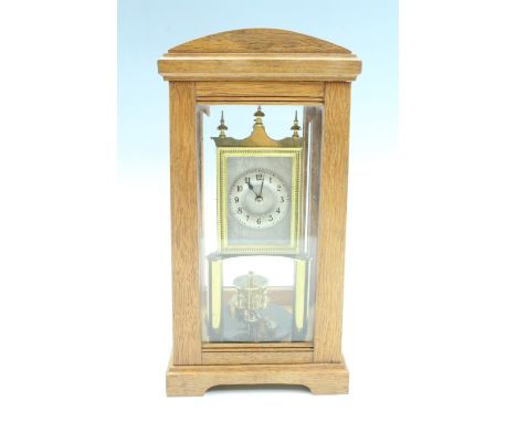 An early 20th Century dome top oak torsion clock, the movement stamped BHA, silvered dial with Arabic numerals, the case havi