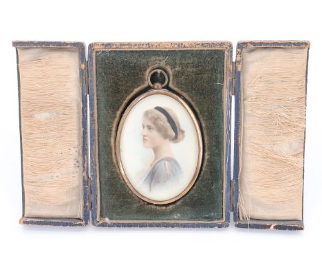 A 1920s portrait miniature of a young lady, in an oval gilt frame with a suspender, in a fitted silk and plush case, 57 x 89 