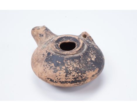 A Roman terracotta oil lamp, of oblate form having a central filling hole, 10.5 x 7.5 x 4 cm