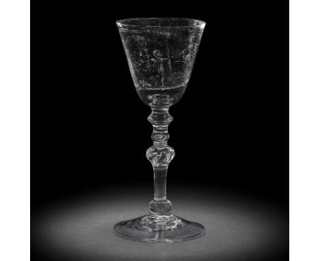 A fine Dutch stipple-engraved light baluster wine glass attributed to 'Gyrinius', circa 1765-75The round funnel bowl finely d