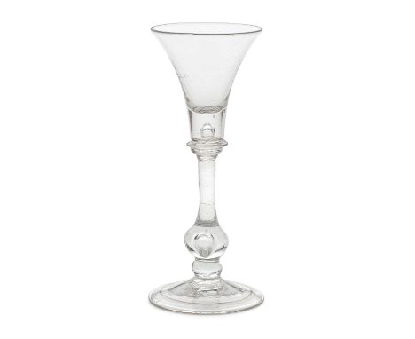 A good baluster wine or cordial glass, circa 1730The flared trumpet bowl with a deep solid base enclosing a tear, on a collar