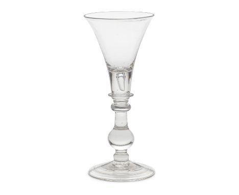 A good baluster wine glass, circa 1720The generous flared trumpet bowl with a deep solid base enclosing a tear, supported by 