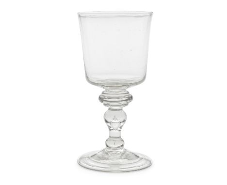 A fine baluster goblet, circa 1725The generous bucket bowl on a stem with a wide triple-annulated shoulder knop above a teare