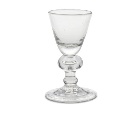 A heavy baluster dram glass, circa 1710Of attractive small size, the round funnel bowl with a solid base, the stem with a wid