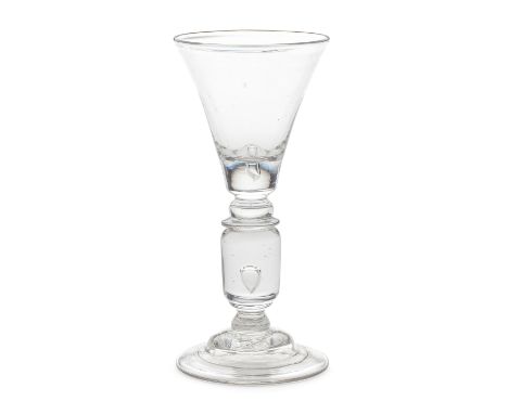 An exceptional cylinder-knopped baluster wine glass, circa 1715-20The generous trumpet bowl with a solid base containing a sm