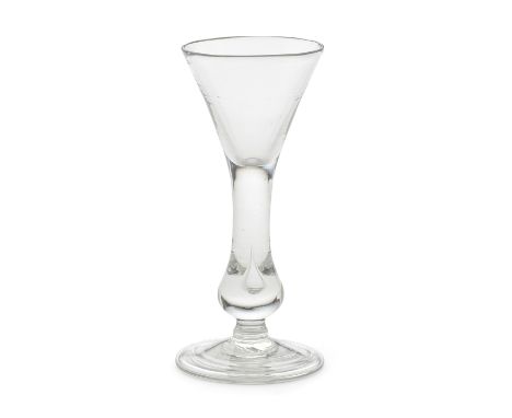 A rare baluster wine glass, circa 1720-30With a conical bowl extending into a true baluster stem containing a small tear, ter