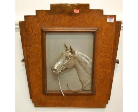 An early 20th century painted alloy relief horses head portrait in Art Deco oak surround