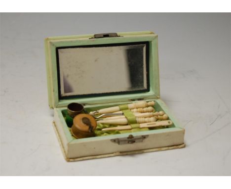 A ladies travelling vanity box comprising assorted bone needlework tools, tape measure, thimble etc