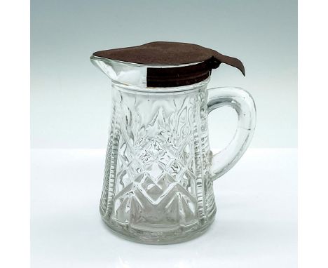 A clear glass pitcher with vertical and diamond cuts, and metal hinged lid. Dimensions: 4.25"L x 3"W x 4.5"HCondition: Age re